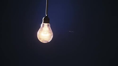Classic Bulb on Wire Sways and Lights Up with Flickers on Blue Background