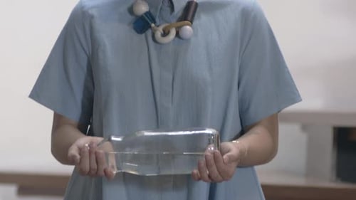 Hermosa latina de cerca y sosteniendo una botella de agua de vidrio