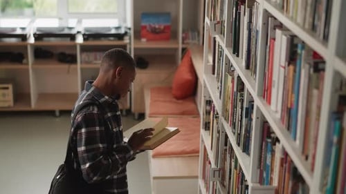 Young Adult Reading a Book in Library