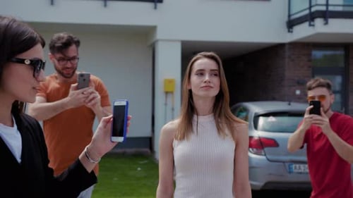 Model poses as people take photos in suburban neighborhood