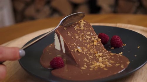Closeup of a Woman Eating a Chocolate Cake with a Spoon in a Cafe