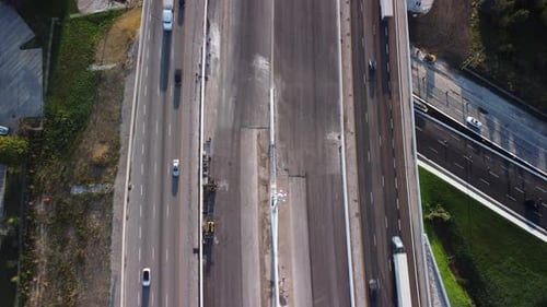 Vue aérienne statique du haut vers le bas d'une autoroute à 3 voies dans un sens. Circulation légère, prise à l'heure dorée.