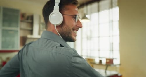 Authentic close up shot of an young carefree happy man wearing white headphones is having fun to l
