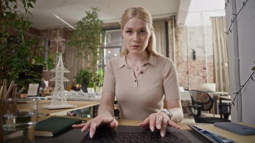 Woman Typing on Laptop with Electric Tower Layout on Desk in Creative Office