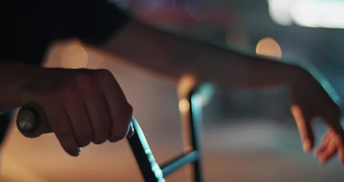 Arm Resting on Scooter Handlebars at Night