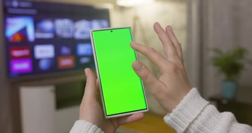 Closeup of Woman Hands Holding Smartphone with Green Screen in Vertical Position