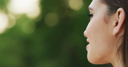 4k footage of an attractive young woman seated in a park by herself outside during the day