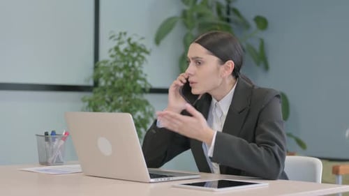 Businesswoman Talking on Phone in Office
