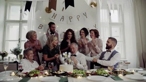 Un hombre mayor con una familia multigeneracional que celebra Birtay en una fiesta bajo techo