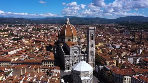 Drone spinning around Cathedral of Santa Maria del Fiore and city on a sunny day in Florence in Ital