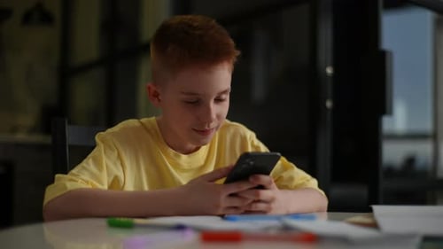 Child Using Mobile Phone at Table Indoors