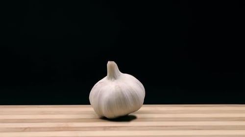 Head of garlic enters, stops and exits the scene. Stop motion animation.