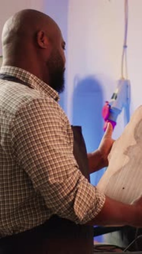 Vertical Video Portrait of Smiling Carpenter in Woodworking Shop Inspecting Wood Block