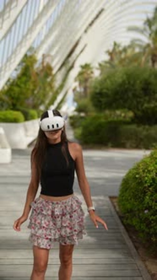 A Woman Enjoys Virtual Reality Technology in a Park Surrounded By Greenery and Nature