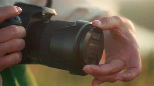 Hands Place the Lens Cap on a Camera