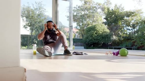 Man Resting During Workout With Phone and Headphones