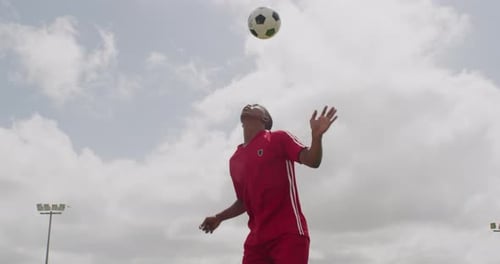 A young soccer player bouncing a soccer ball on his head