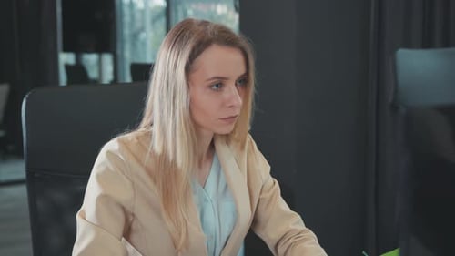 Woman in Beige Jacket Working in Office