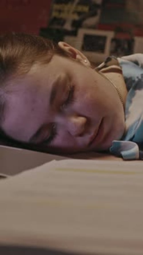 Young Woman Sleeping on Desk with Homework