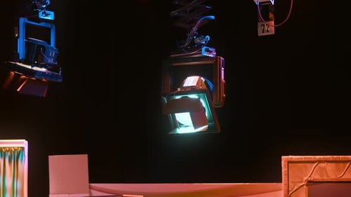 Grid of professional lighting fixtures suspended in a dark television studio