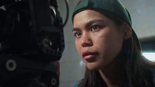 Woman Adjusting Digital Camera in Dark Environment