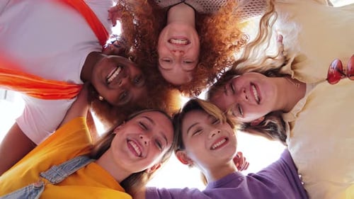 Visão de baixo ângulo de cinco adolescentes rindo e olhando para a câmera Grupo de mulheres jovens sorrindo