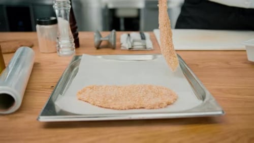 Chef Prepares Breaded Meat in Professional Kitchen