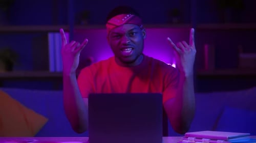 Enthusiastic Young Adult Giving Rock-On Hand Gesture