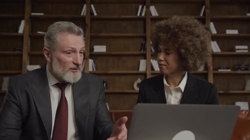 Colegas de negocios en conversación sobre el uso de una computadora portátil