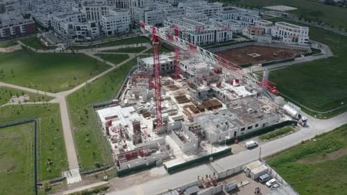 Órbita aérea de 360 grados alrededor de una grúa torre sobre una obra de construcción residencial, que revela un