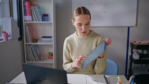 Young Woman Teaching Online Using Tablet and Laptop