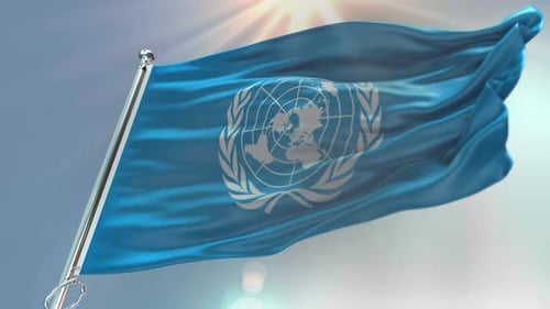 United Nations Flag Waving Against Blue Sky Background
