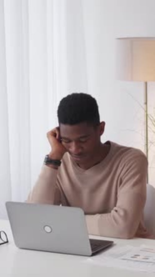 Adult Contemplating Work at Desk With Laptop