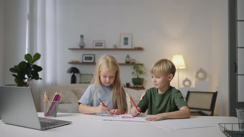 Children Drawing Together at Table with Pencils