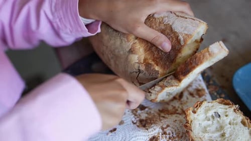 Slicing Fresh Bread with Knife at Home