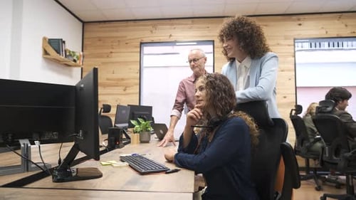 Colegas de trabalho felizes discutindo sobre o projeto no computador no escritório