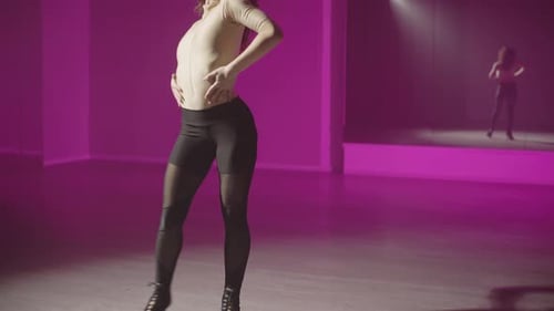 Stylish Woman Dancing in Magenta Lit Studio