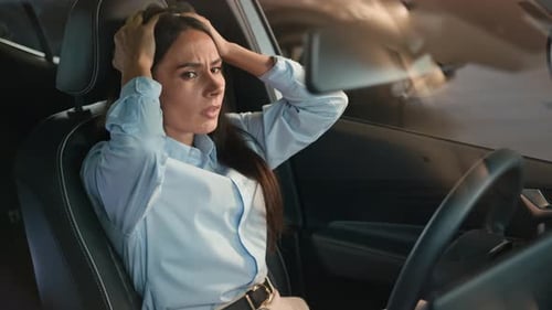 Distressed Woman Sitting in Car Looking Worried