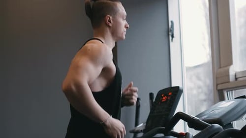 Muscular Male Athlete Exercising on Treadmills in the Modern Gym Doing Fitness Exercise