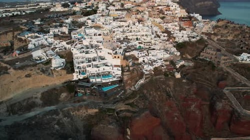 Drone Shot of Santorini Island and Oia Village, Greece, White Buildings on Top Of Red Cliffs