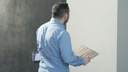 Young homeowner reviews flooring samples and blueprints for new home project