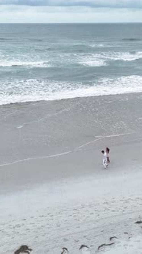 Romantic Couple Holding Hands Walking on the Beach