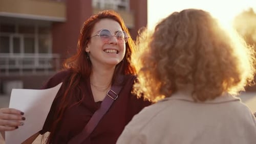 Alegre estudante abraça sua amiga perto da escola