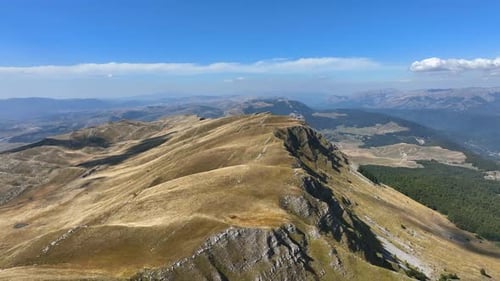 Flight over beautiful mountain peaks covered with grass. Mountain from above on a sunny autumn day.