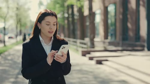 Business Woman Wearing Formal Suit Going to the Business Centre Holding Using the Mobile Phone