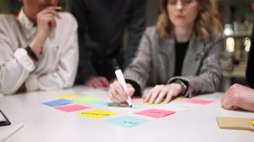 Business Team Brainstorming Using Color Labels On Table In Office Woman Is Writing On Stickers