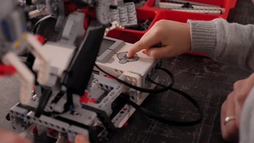 Nahaufnahme von Kindern, die aus einem Roboterkonstrukteur an einem Schreibtisch einen Roboter bauen