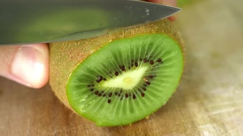 Close up of cut slice healthy vegan kiwi fruit to get vitamins. For salad, eat raw or make smoothie