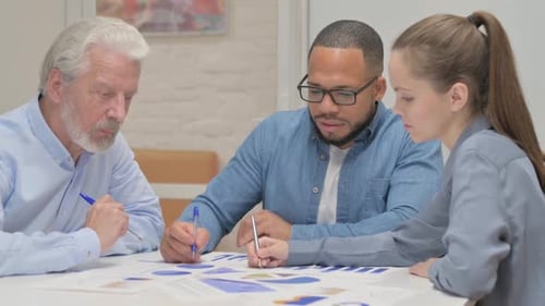 Hispanic Man Working on Documents with Colleagues