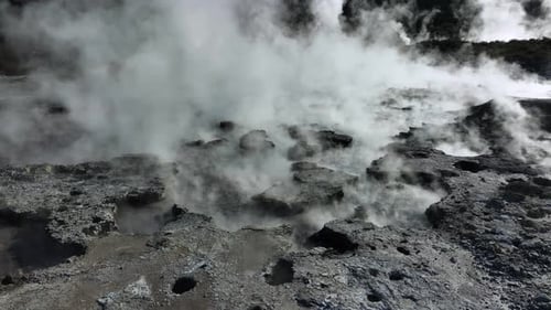 Bubbling geothermal mud, Drone slowly flying over geothermal landscape. Trees, steam, bubbling mud a